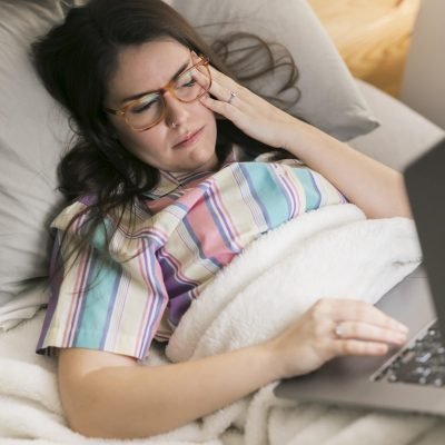 mid-shot-brunette-woman-staying-bed-working-laptop