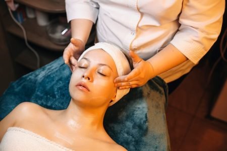 upper-view-adult-woman-having-facial-massage-while-leaning-spa-bed-waiting-with-anti-age-mask-her-face_129180-4208